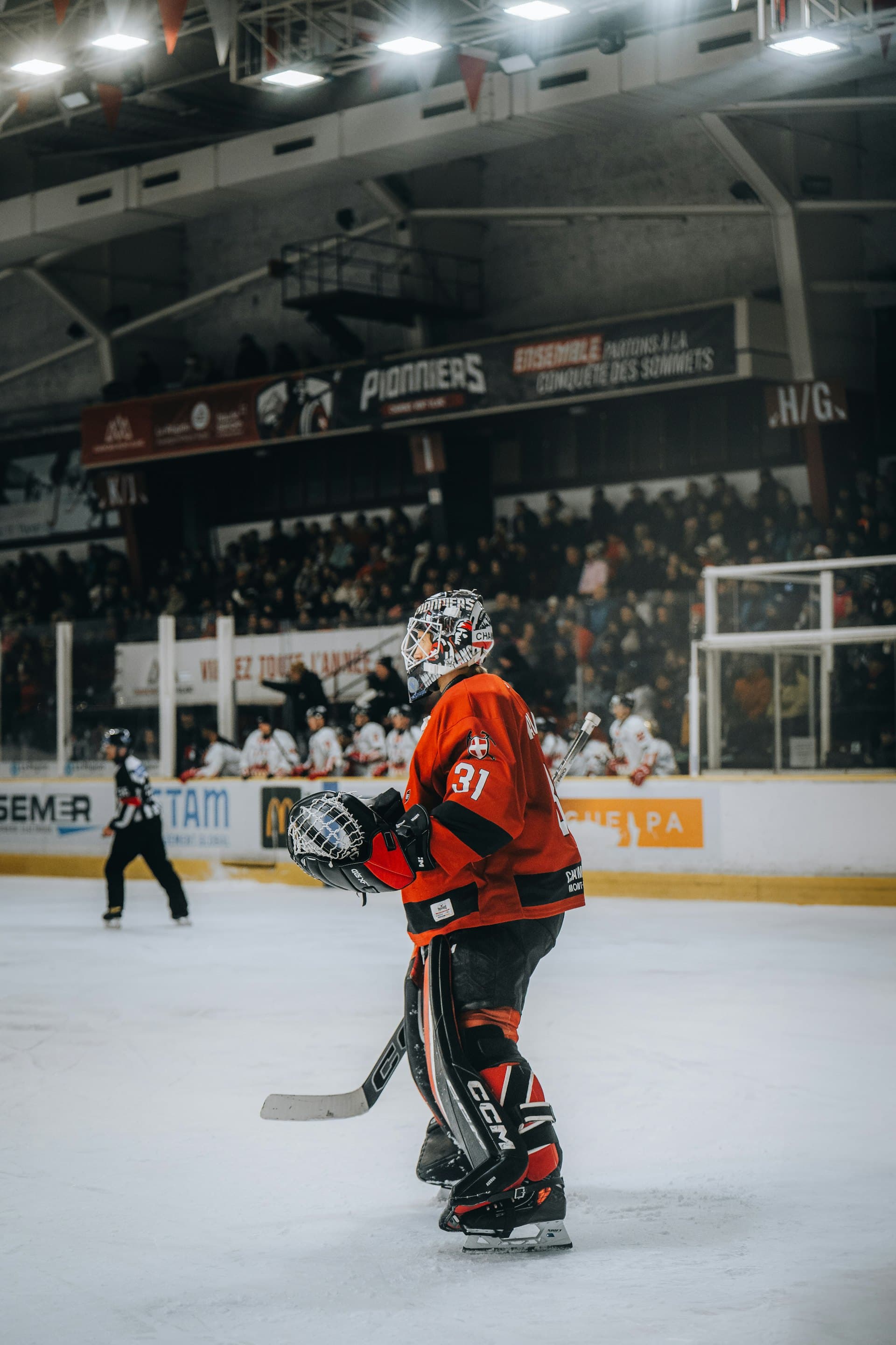 An ice hockey player on the ice in an arena